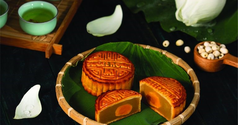 Bánh trung thu hạt sen trứng muối SweetHome cắt đôi trên lá sen